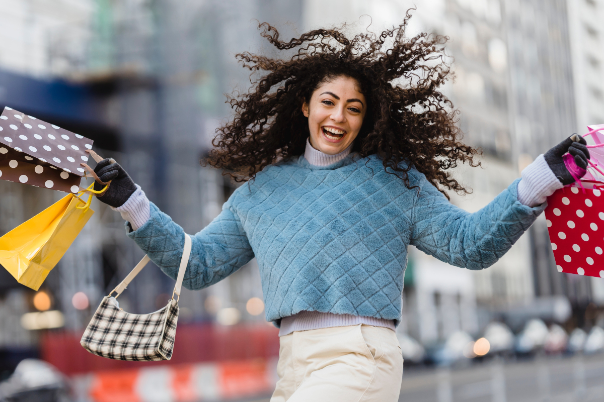 https://www.pexels.com/photo/happy-woman-jumping-with-shopping-bags-6567607/